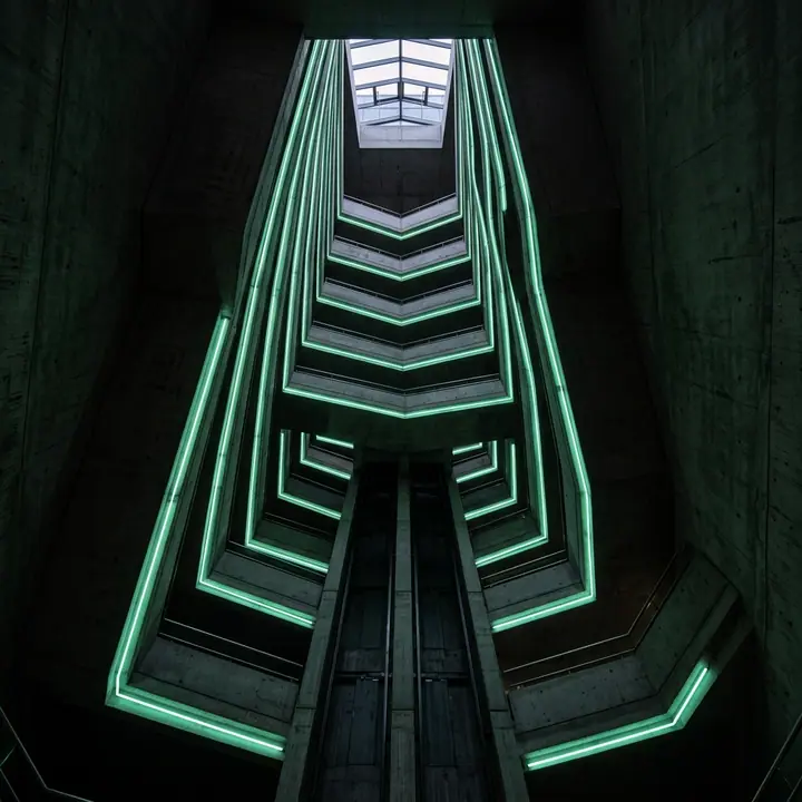Straight up a dark concrete atrium, one mint line running the edge
