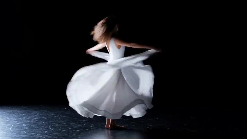 She spins and the dress goes with her, one hard light from the side