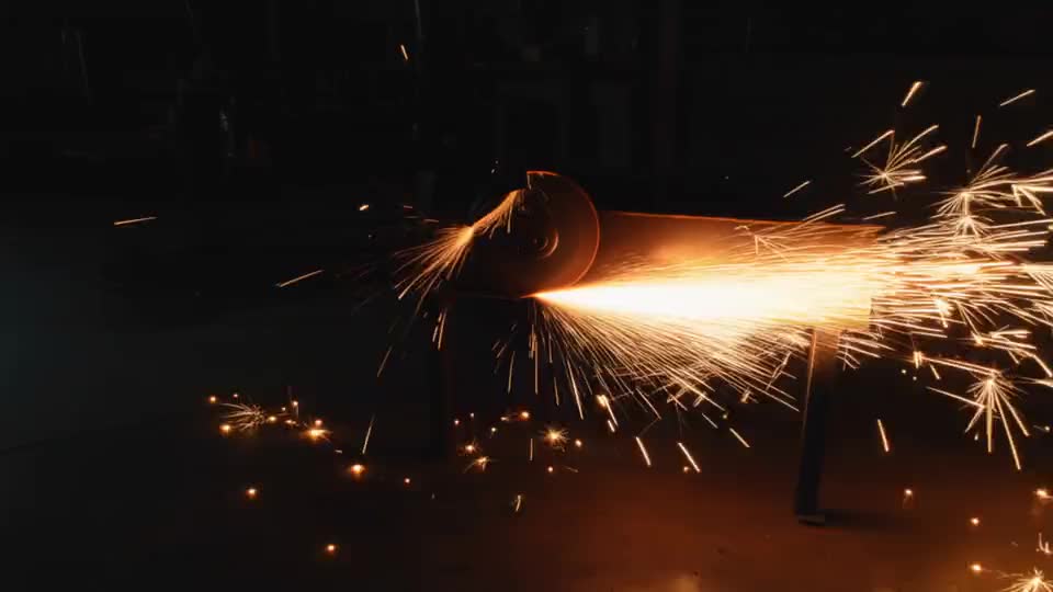 The grinder bites into steel and throws sparks across the shop